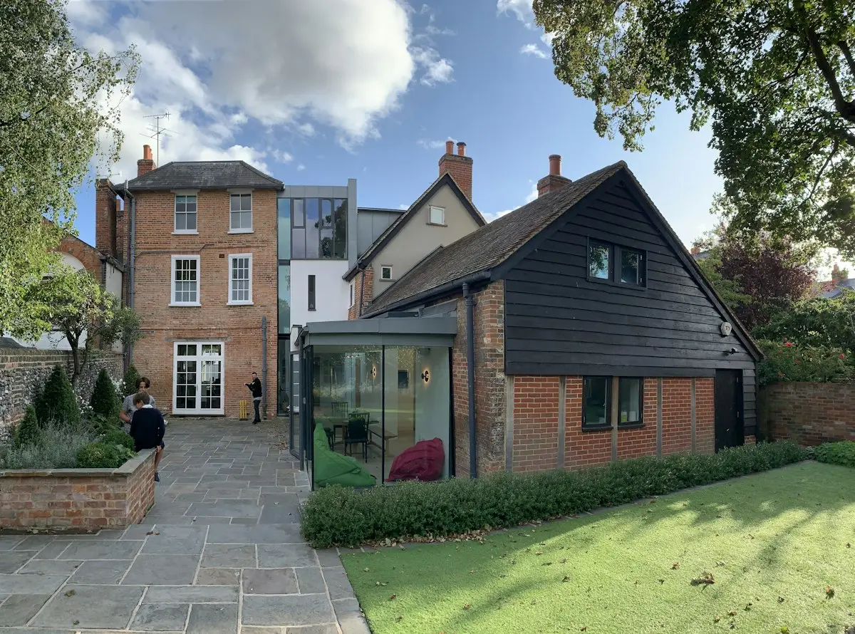 Brick house with a new timber clad rear extension and lawn