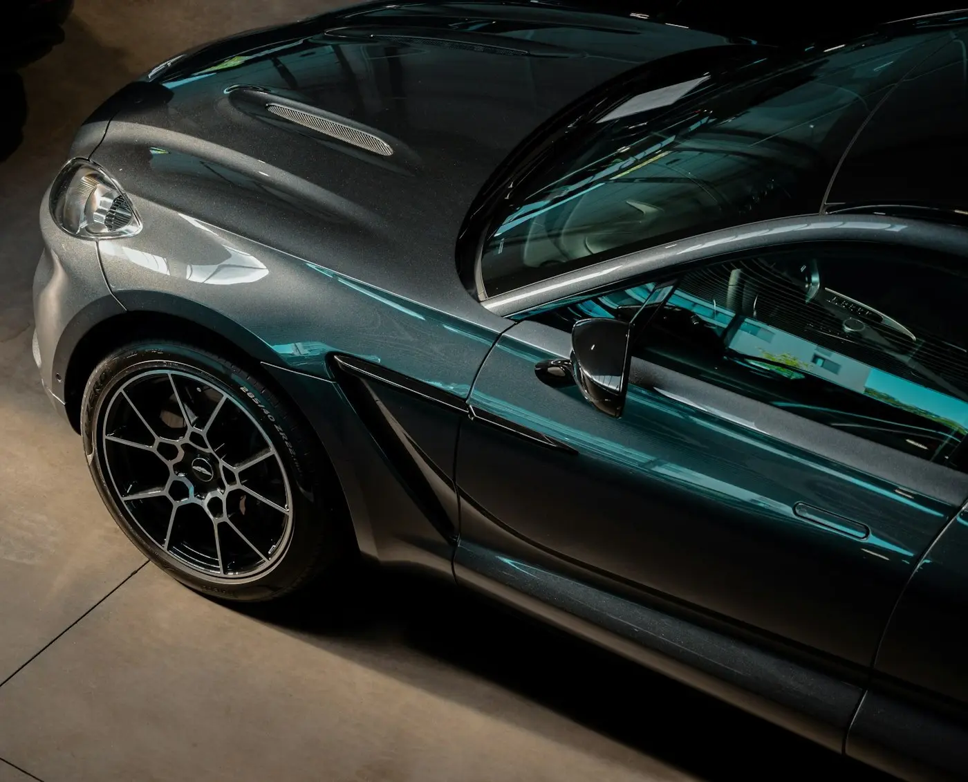 Dark green grand tourer parked in the showroom