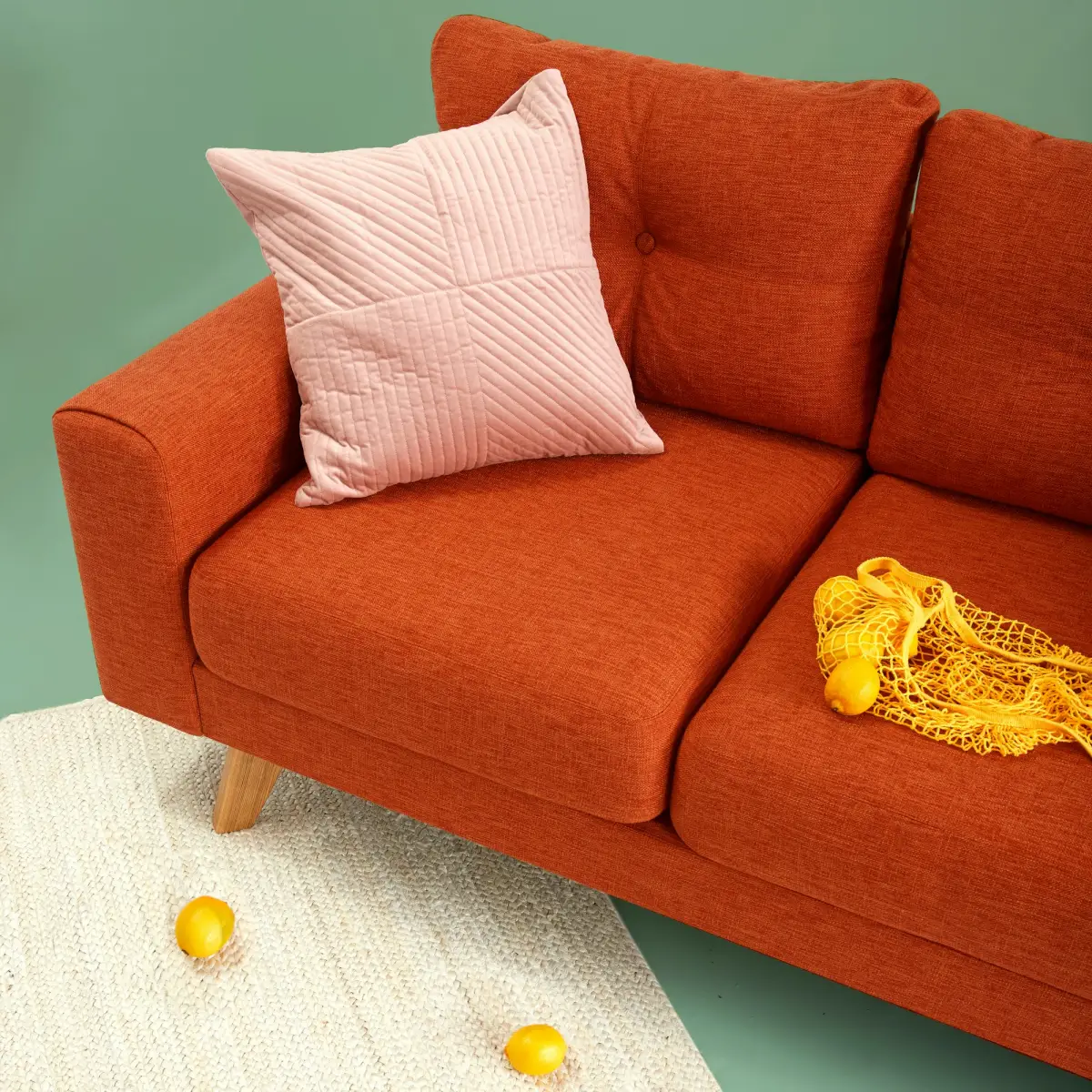 Burnt orange sofa with a pink cushion