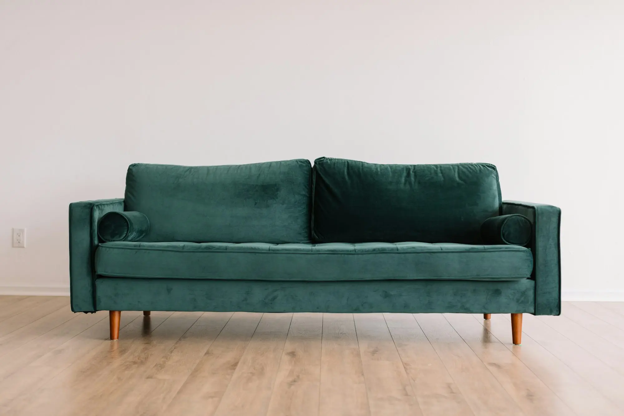 Green velvet sofa in a bright showroom